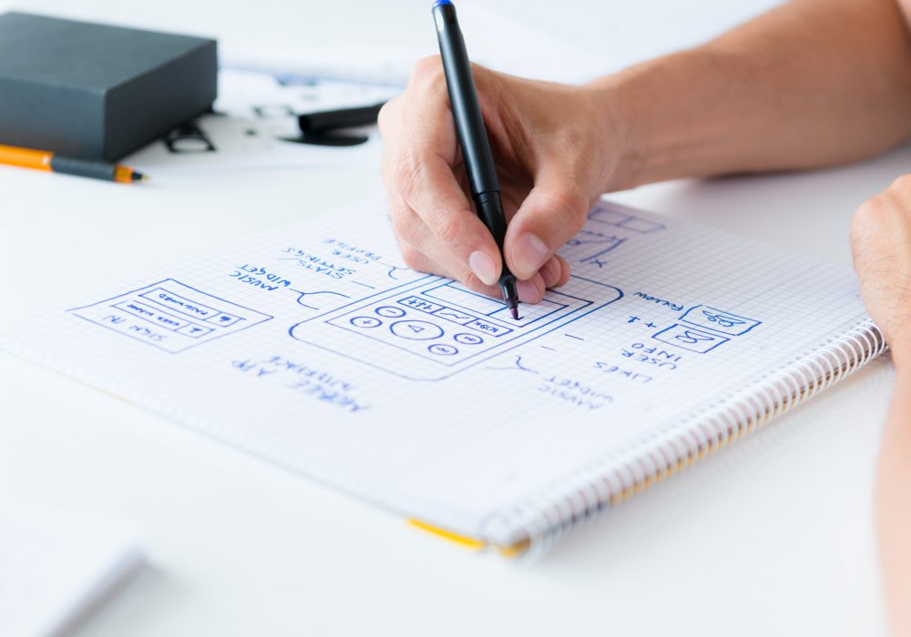 Designer develop a mobile application usability and drawing its framework on a paper.